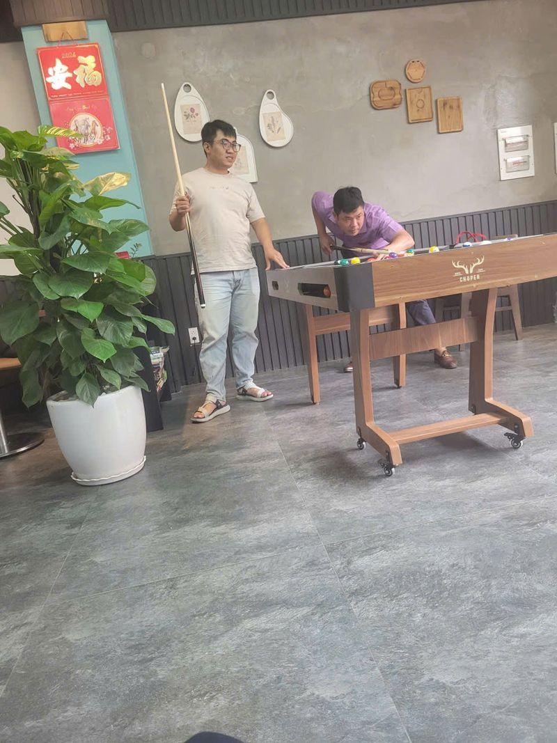 Hai khách chơi bàn bida mini Choper gấp gọn có bánh xe trong quán cafe